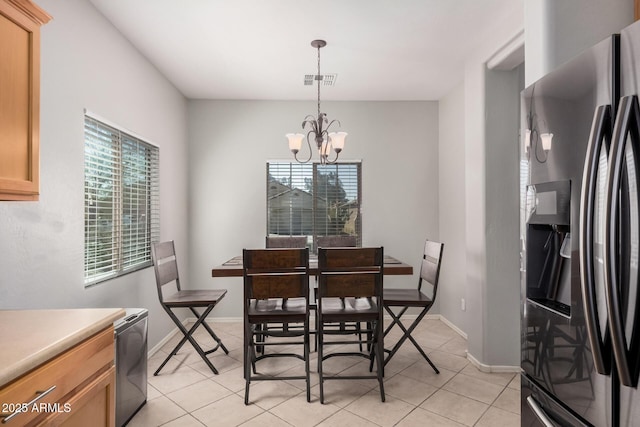 dining room with light tile patterned floors, visible vents, baseboards, and a notable chandelier