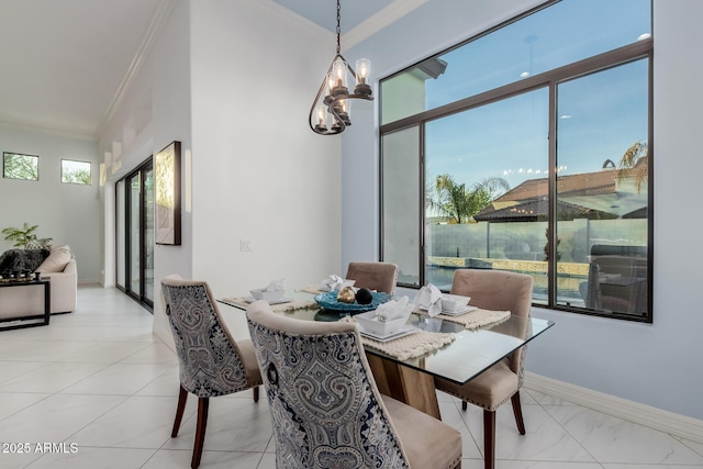 dining space with an inviting chandelier, baseboards, and ornamental molding