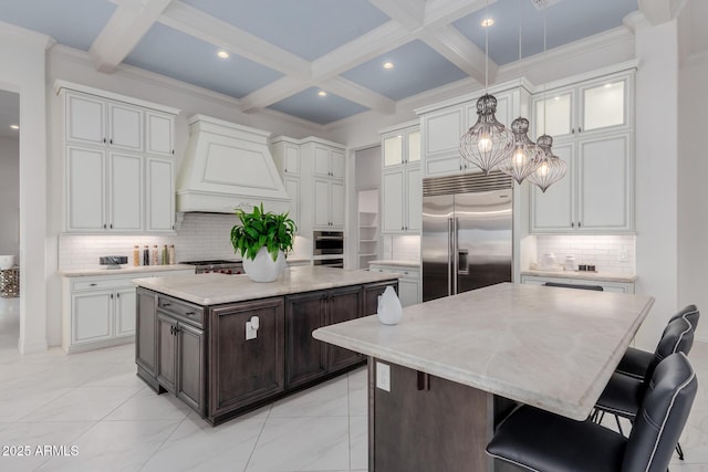 kitchen featuring a center island, dark brown cabinetry, stainless steel appliances, and custom range hood