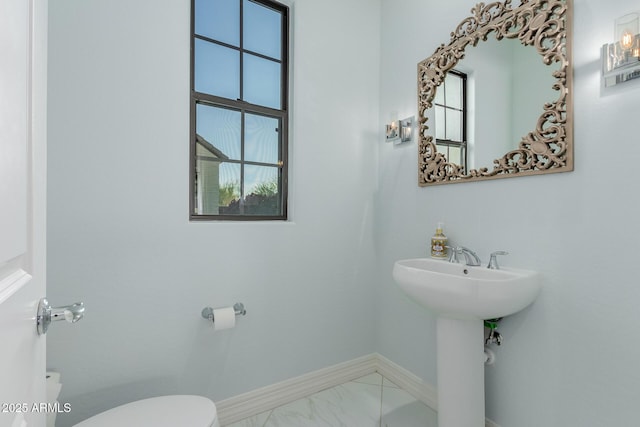 bathroom featuring sink, a wealth of natural light, and toilet