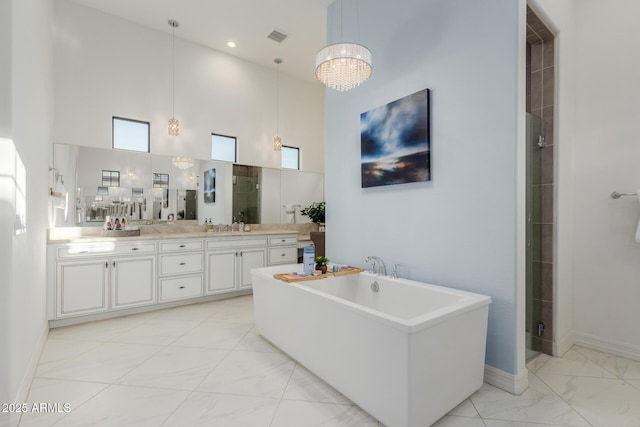 bathroom with a towering ceiling, vanity, and plus walk in shower