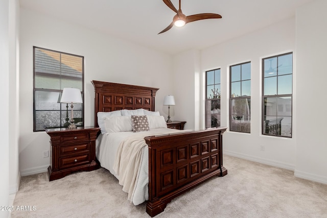 bedroom featuring a ceiling fan, baseboards, and light carpet