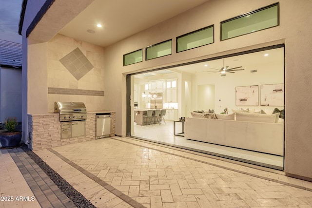 view of patio with an outdoor kitchen, a grill, and ceiling fan