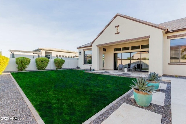 back of house featuring a patio, a lawn, fence, and stucco siding