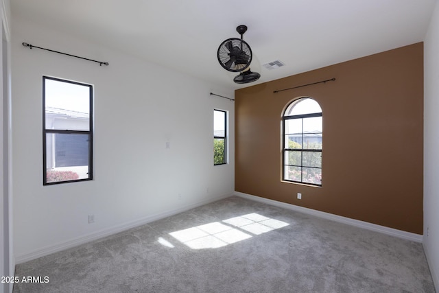 carpeted empty room featuring visible vents and baseboards