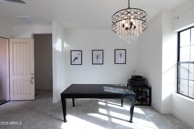 carpeted home office featuring a notable chandelier