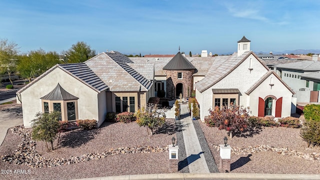 view of front of home with metal roof, stone siding, stucco siding, and a standing seam roof