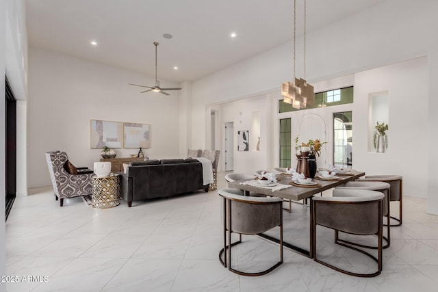 dining area with a high ceiling, recessed lighting, and ceiling fan