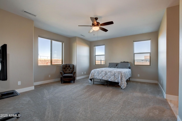 bedroom with multiple windows, light colored carpet, visible vents, and baseboards