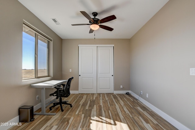 office area with visible vents, baseboards, wood finished floors, and a ceiling fan