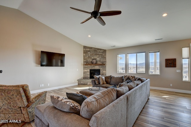 living room featuring visible vents, baseboards, vaulted ceiling, light wood-style flooring, and a fireplace