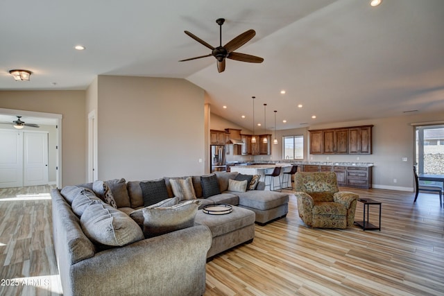 living area featuring lofted ceiling, light wood-type flooring, and a wealth of natural light