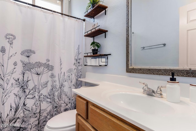 bathroom featuring a shower with curtain, vanity, and toilet