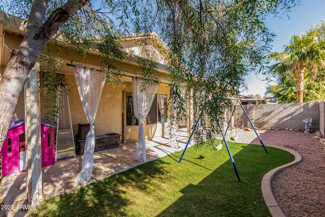 back of property with a playground, a patio, and a yard