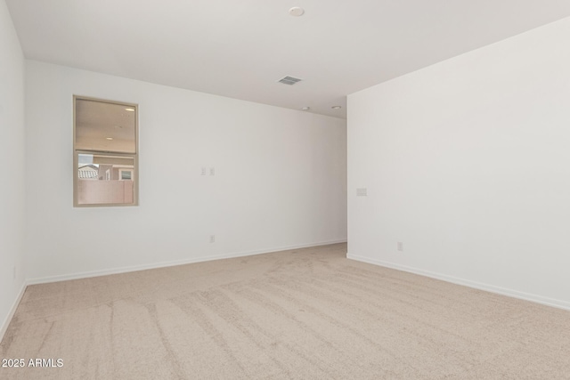 empty room featuring visible vents, baseboards, and carpet