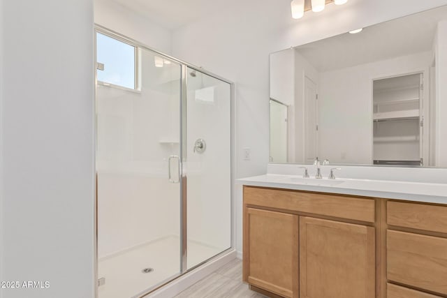 bathroom featuring a closet, a stall shower, and vanity