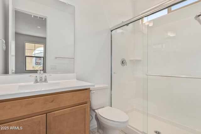 bathroom featuring vanity, toilet, visible vents, and a stall shower