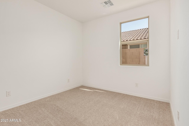 carpeted empty room featuring visible vents and baseboards