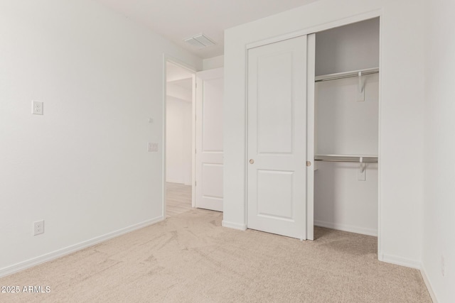 unfurnished bedroom featuring visible vents, baseboards, carpet, and a closet