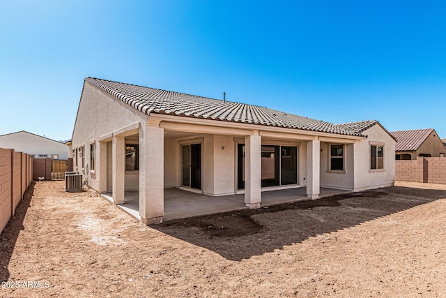 rear view of house with a tile roof, central AC unit, stucco siding, a fenced backyard, and a patio area