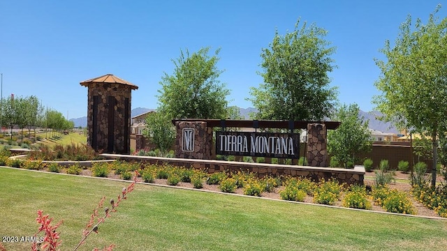 community sign featuring a lawn and fence