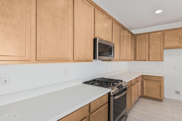 kitchen with light countertops, light tile patterned floors, recessed lighting, appliances with stainless steel finishes, and brown cabinetry