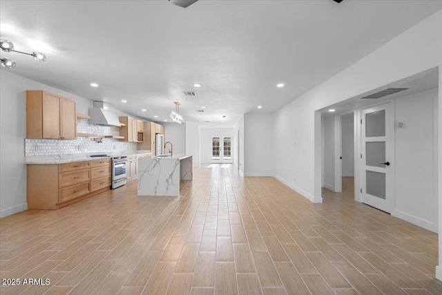 4400 N 20th St, Phoenix, AZ 85016 - kitchen featuring stainless steel range oven, wall chimney exhaust hood, recessed lighting, light wood-style floors, and backsplash
