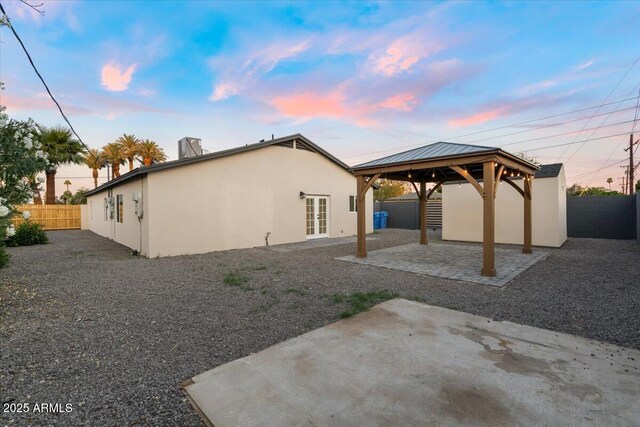 4400 N 20th St, Phoenix, AZ 85016 - back of property at dusk featuring a patio area, a gazebo, french doors, a fenced backyard, and stucco siding