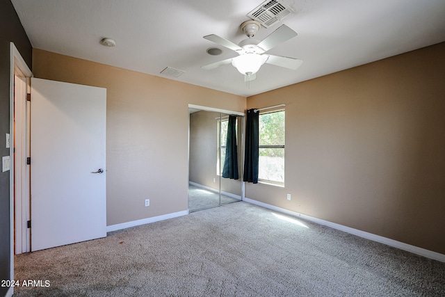 unfurnished bedroom featuring light colored carpet, ceiling fan, and a closet