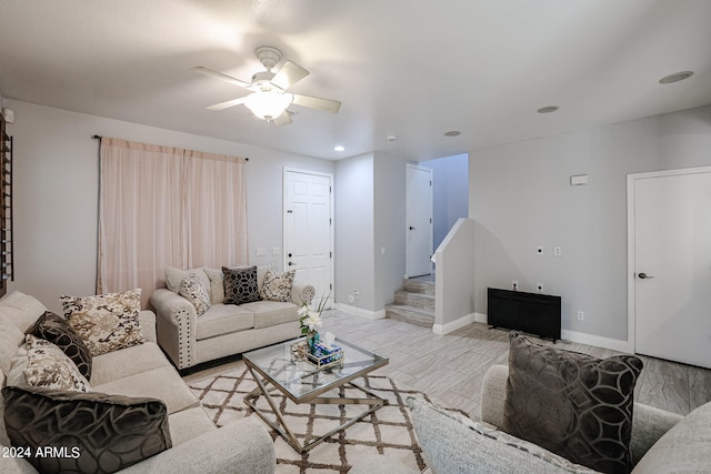 living room featuring light hardwood / wood-style flooring and ceiling fan