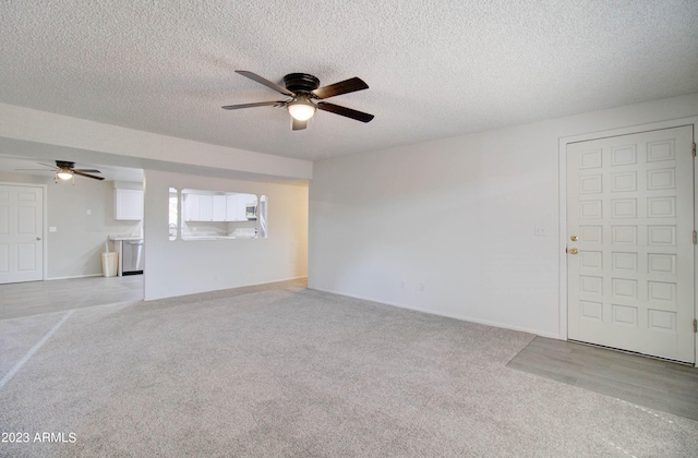 unfurnished living room with ceiling fan, light colored carpet, and a textured ceiling