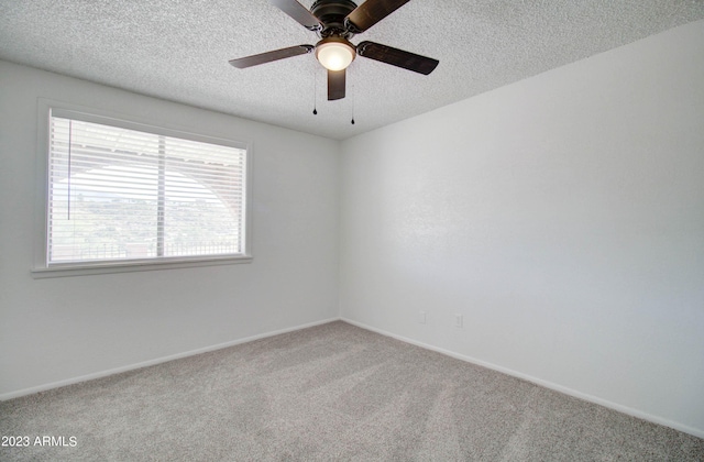 carpeted spare room with ceiling fan and a textured ceiling