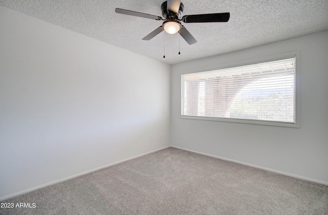 empty room with ceiling fan, carpet flooring, and a textured ceiling