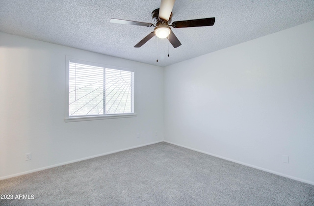 empty room featuring ceiling fan, a textured ceiling, and carpet flooring