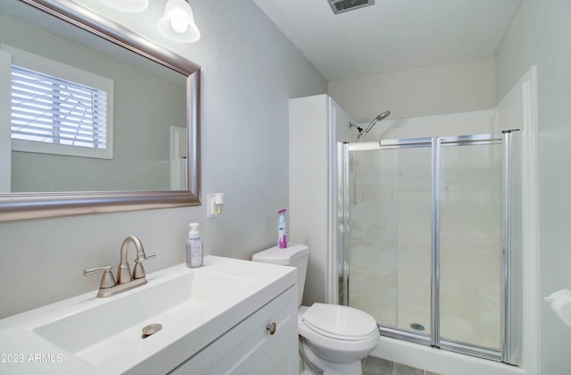 bathroom featuring walk in shower, vanity, and toilet