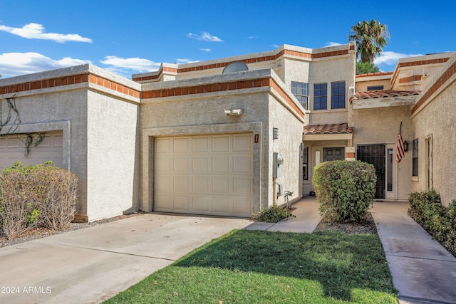 view of property featuring a front yard and a garage