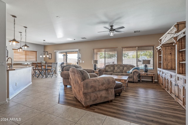 tiled living room featuring a textured ceiling and ceiling fan