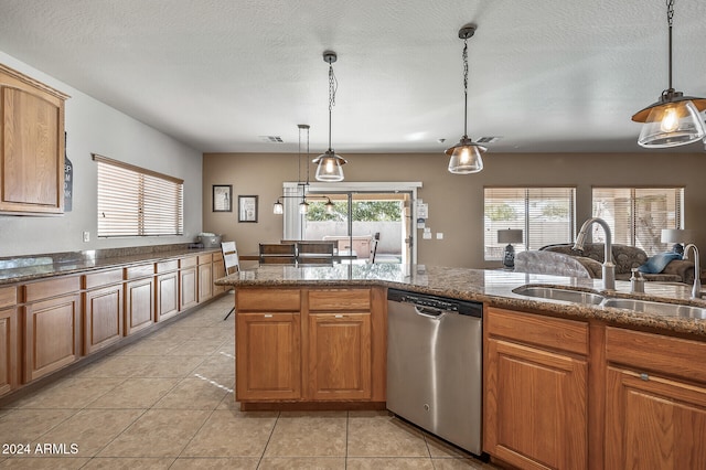 kitchen with stainless steel dishwasher, sink, hanging light fixtures, and a textured ceiling