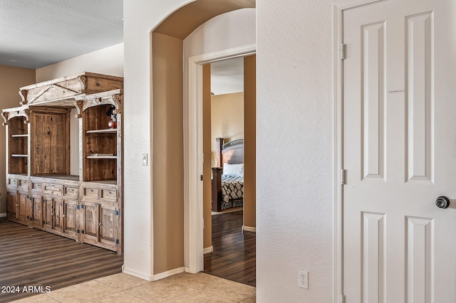 hallway featuring light hardwood / wood-style floors and a textured ceiling