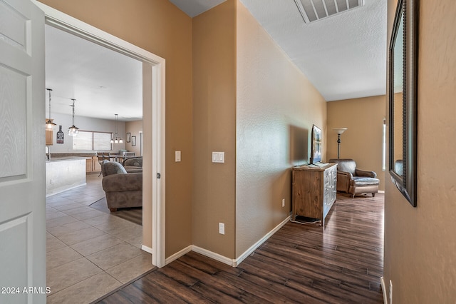 hallway featuring an inviting chandelier and hardwood / wood-style floors