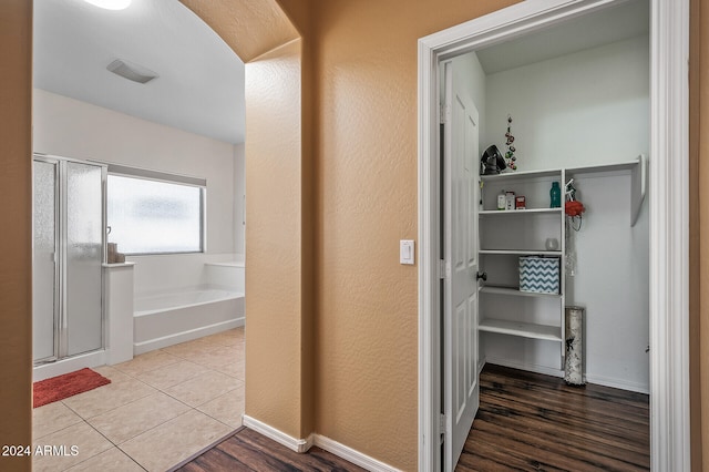 bathroom featuring hardwood / wood-style flooring and plus walk in shower