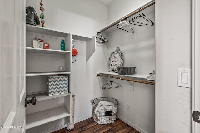 walk in closet with dark wood-type flooring