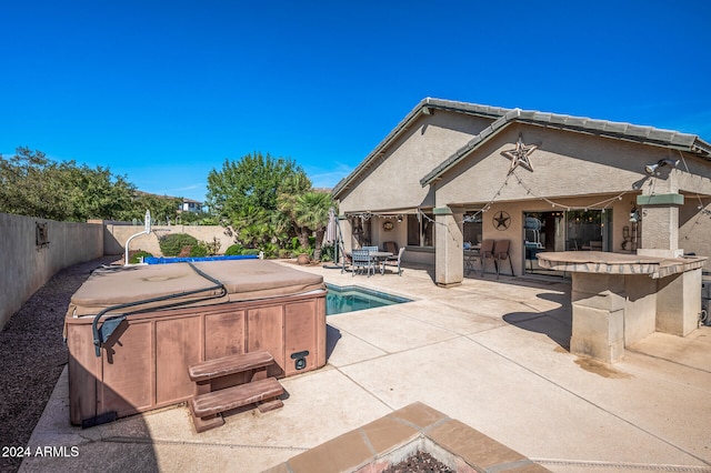 view of pool with a patio area and a hot tub