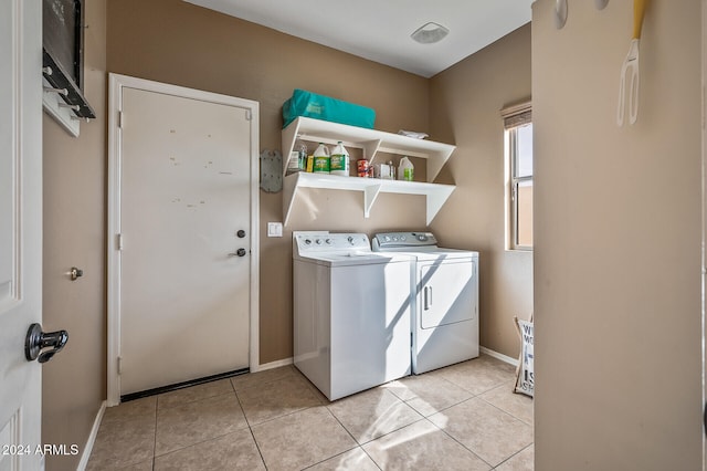 clothes washing area featuring light tile patterned floors and washer and clothes dryer