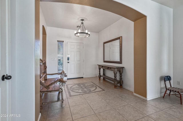 tiled entrance foyer with a chandelier