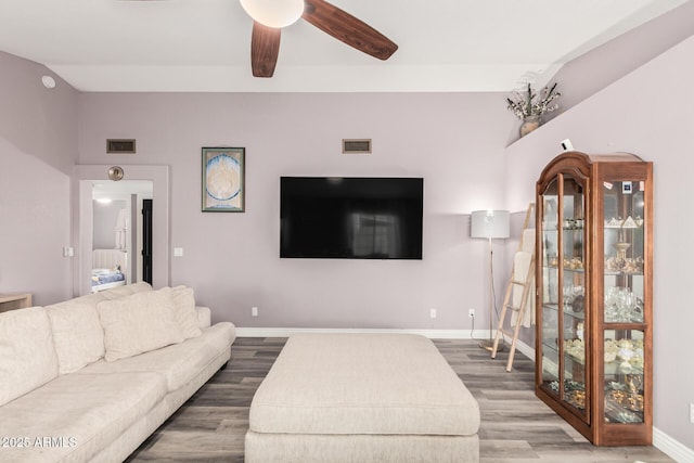 living room featuring hardwood / wood-style flooring, ceiling fan, and vaulted ceiling