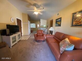 carpeted living room with lofted ceiling and ceiling fan