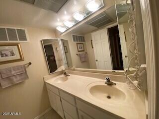 bathroom with double vanity, visible vents, and a sink