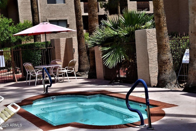 view of pool with a community hot tub, a patio, and fence