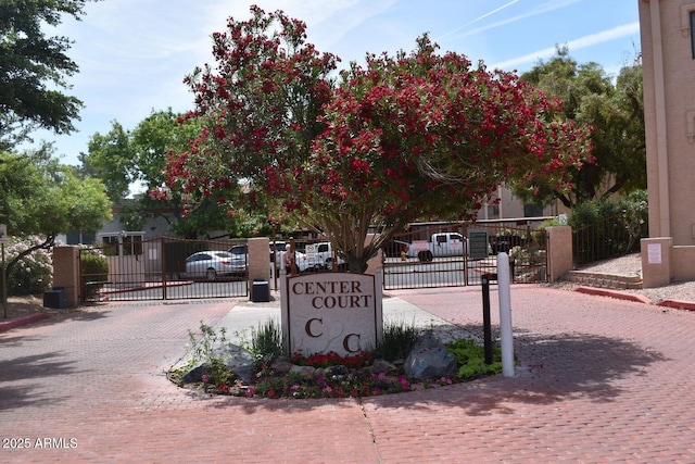 community sign featuring fence and a gate